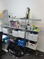 Reol med indhold af diverse bolde, bøger, hobbyting, m.v.