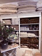 Indhold af reol - Puder, tæpper, lys mm.