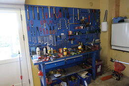 Arbejdsbord med skruestik samt værktøjstavle med div. Værktøj