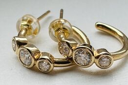 Et par ørestikker/hops af 14 kt. guld hver prydet med tre brillantslebne laboratorieskabte diamanter