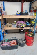 Indhold på reol af diverse stropper, spande, dunke mv.