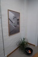 Indrammet plakat, plante i krukke samt skål