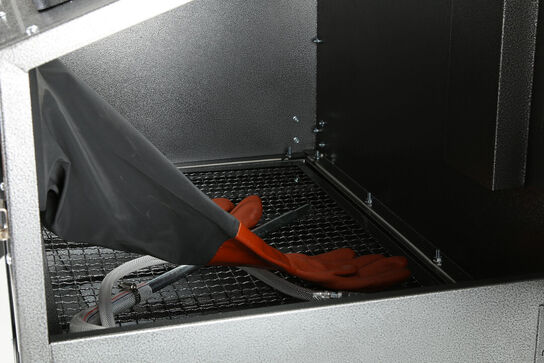 Sandblæsekabinet med tætnede handsker. Blæsematerialet recirkuleres og genanvendes indtil det er brugt eller har mistet sin slibende virkning.