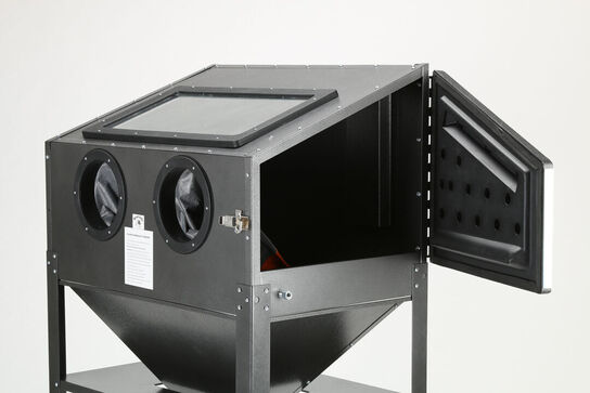 Sandblæsekabinet med tætnede handsker. Blæsematerialet recirkuleres og genanvendes indtil det er brugt eller har mistet sin slibende virkning.