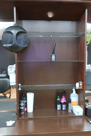 Vægmonteret møbel med spejl med bl.a. ventilator, varelager, hårtørrer, voks m.m. (indhold i reol i midten, medfølger ikke)