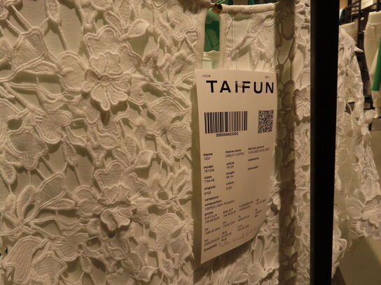 Udstilling med møbler, reol og tøjet på stativer og borde