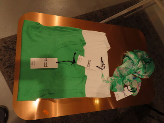 Udstilling med møbler, reol og tøjet på stativer og borde