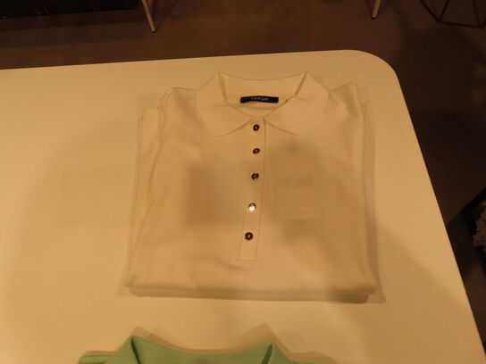 Udstilling med møbler, reol og tøjet på stativer og borde