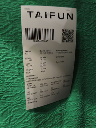 Udstilling med møbler, reol og tøjet på stativer og borde