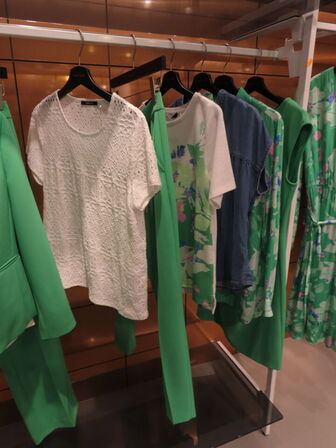 Udstilling med møbler, reol og tøjet på stativer og borde