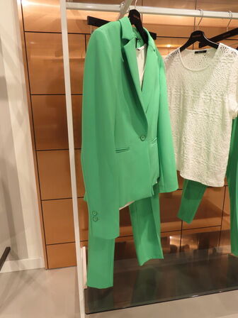 Udstilling med møbler, reol og tøjet på stativer og borde