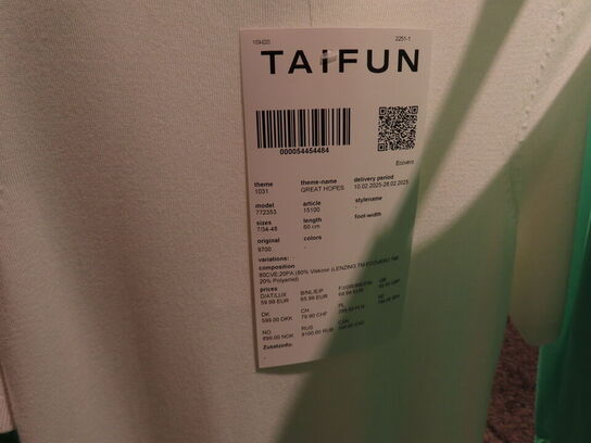 Udstilling med møbler, reol og tøjet på stativer og borde