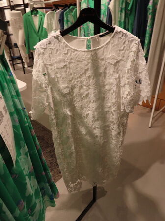 Udstilling med møbler, reol og tøjet på stativer og borde