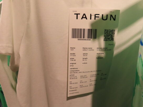 Udstilling med møbler, reol og tøjet på stativer og borde