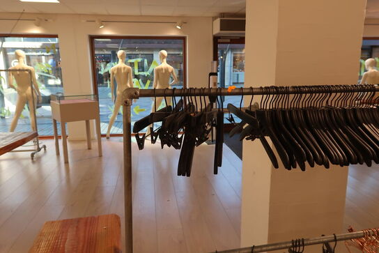 Tøjtstativ med bøjler samt stænger på væg