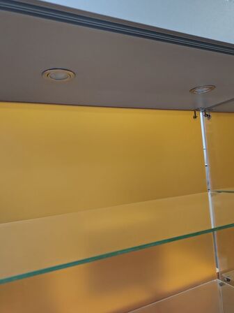 Glasmontre med hjul og lys.