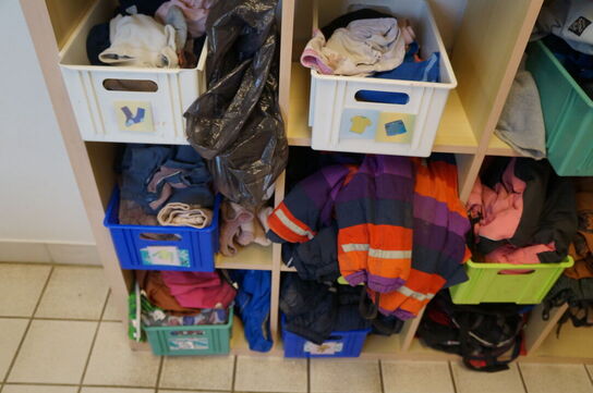 Reol med indhol af diverse børnetøj