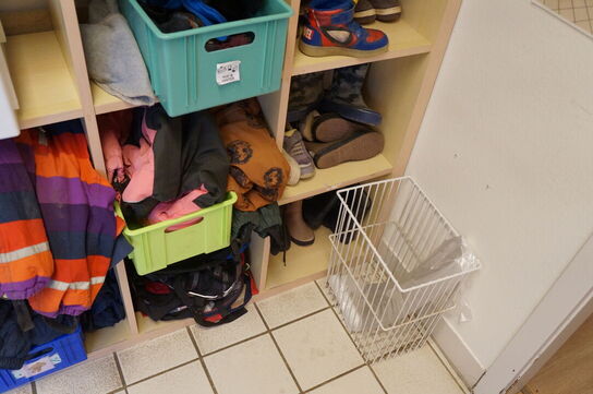 Reol med indhol af diverse børnetøj