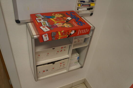 Reol med indhol af diverse børnetøj