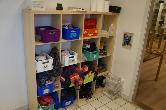 Reol med indhol af diverse børnetøj
