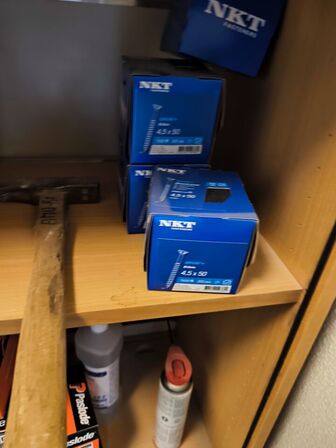 Indhold på reol (PASLODE stifter m.v.) samt hammer, målepind m.m.