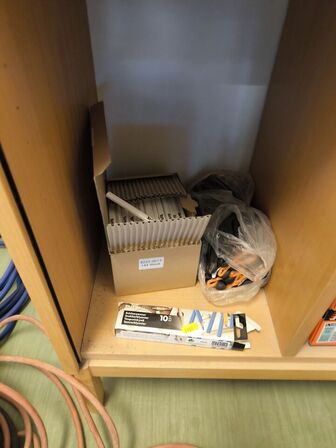 Indhold på reol (PASLODE stifter m.v.) samt hammer, målepind m.m.