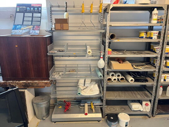 Reoler med indhold, samt møbler i rummet.