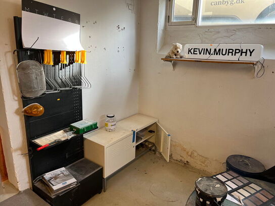 Reoler med indhold, samt møbler i rummet.