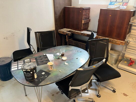 Reoler med indhold, samt møbler i rummet.