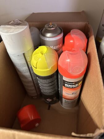 Indhold på reol af diverse spraydåser, fuge mv.