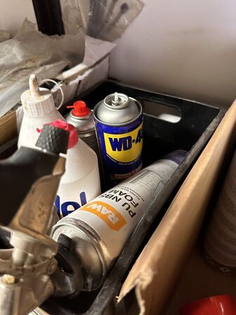 Indhold på reol af diverse spraydåser, fuge mv.