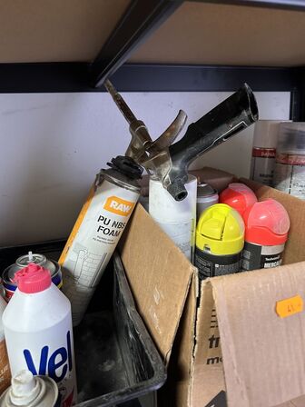 Indhold på reol af diverse spraydåser, fuge mv.