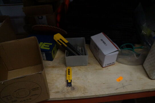 Indhold på reol af diverse knivblade, arbejdshandsker, m.v.