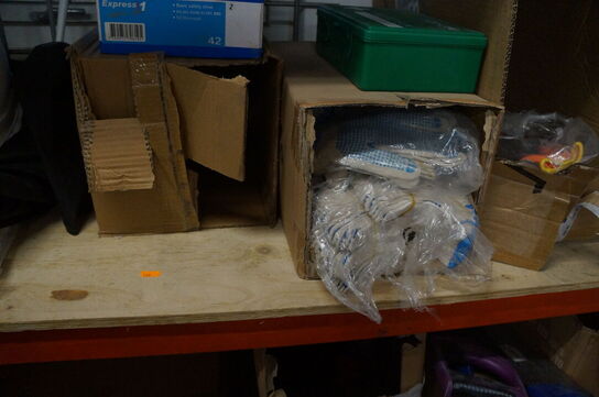 Indhold på reol af diverse knivblade, arbejdshandsker, m.v.