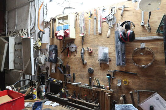 Arbejdsbord med skruestik, div. Værktøj, varelager m.m.