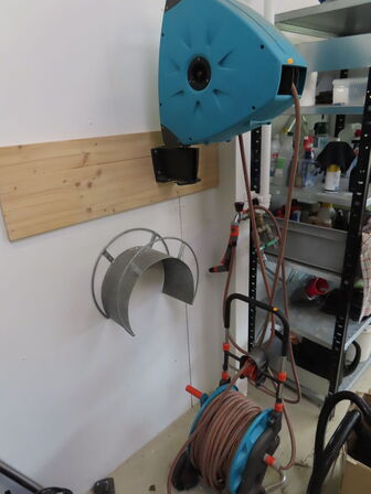 Haveslange med oprug til væg og ekstra forlænger på stativ.