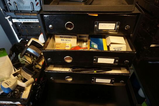 Reol med indhold af toner, lim, tuscher mv