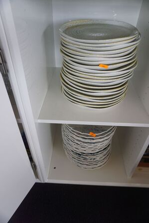 Indhold i skab af diverse tallerkner, bestik, glas mv.