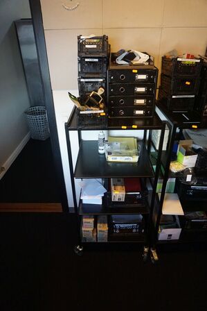 Reol med indhold af toner, lim, tuscher mv