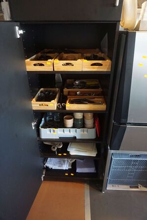 Indhold på 5 hylder af bestik, skærebræt, skåle mv. 