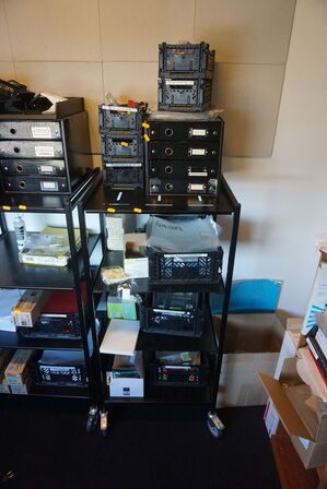 Reol med indhold af plastiklommer, tuscher mv