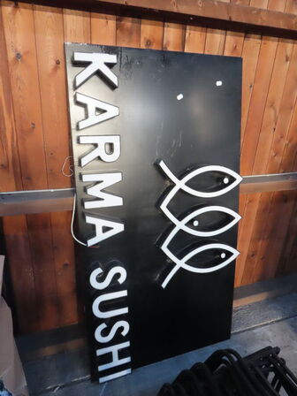 Skilt KARMA SUSHI samt stoleben