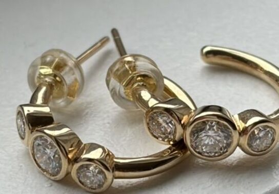 Et par ørestikker/hops af 14 kt. guld hver prydet med tre brillantslebne laboratorieskabte diamanter