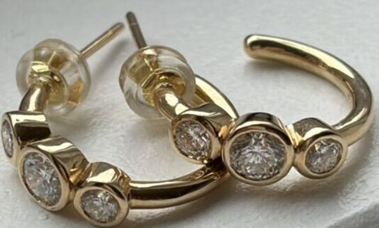 Et par ørestikker/hops af 14 kt. guld hver prydet med tre brillantslebne laboratorieskabte diamanter