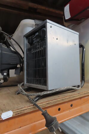 Indhold på reol af diverse lamper, varmeblæser, lysstofsrør mv.