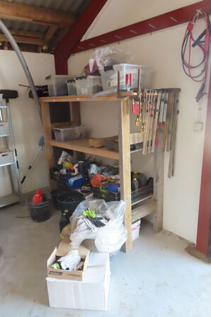 Indhold på reol af diverse skruetvinger, kabler, spande mv.