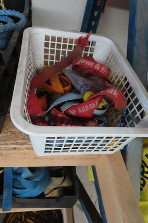 Indhold på reol af diverse stropper, spande, dunke mv.