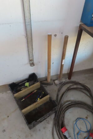 Værkstedsbord med indhold af diverse værktøj, slanger mv.