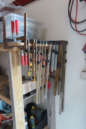 Indhold på reol af diverse skruetvinger, kabler, spande mv.