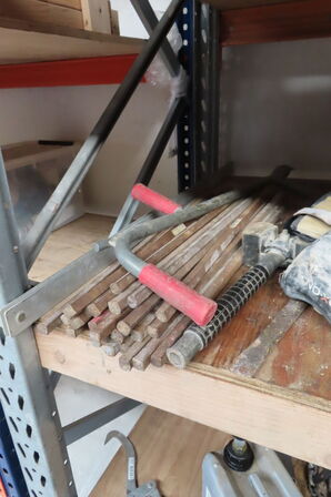 Indhold på reol af diverse lamper, varmeblæser, lysstofsrør mv.